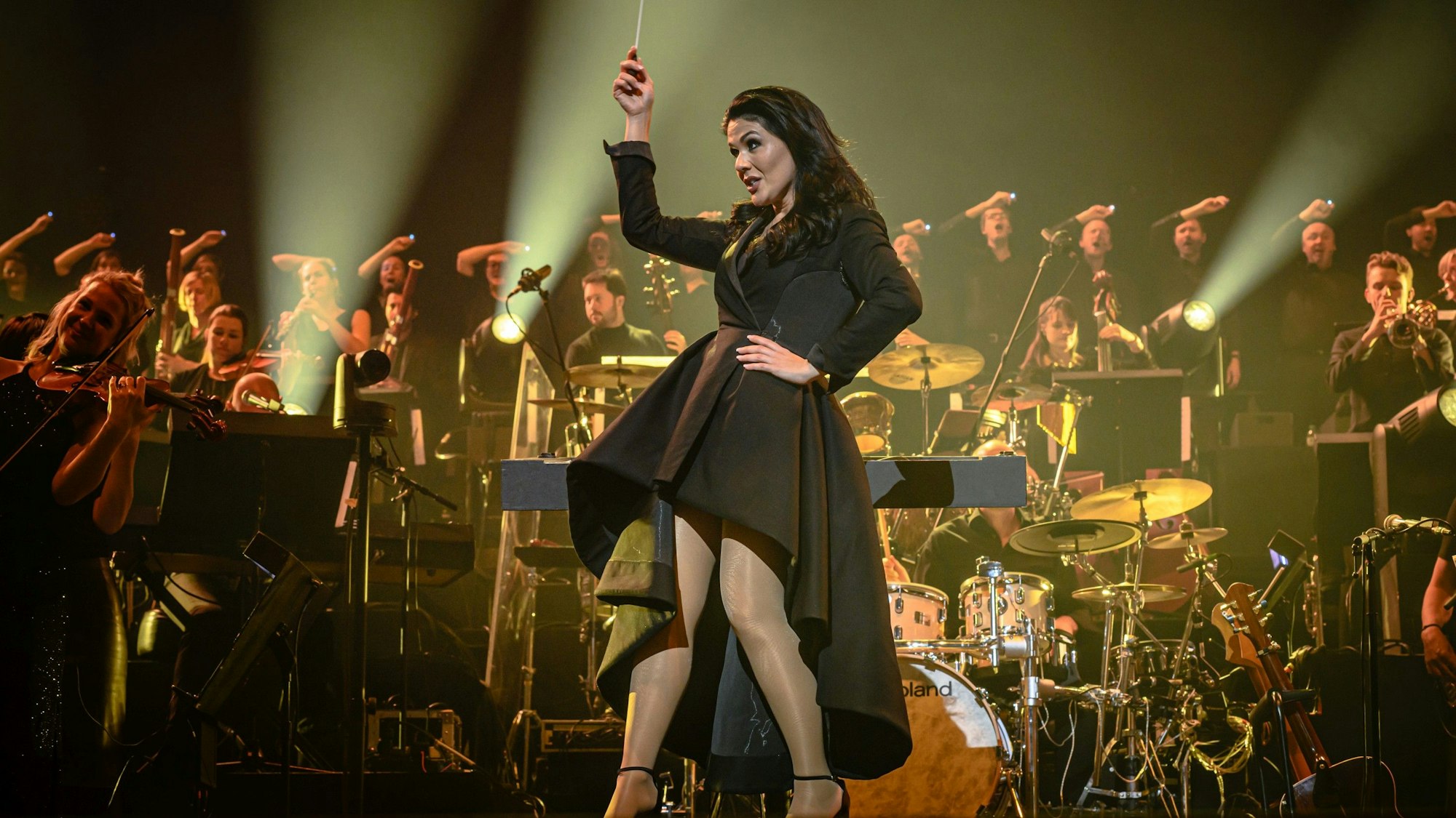 Ein Hauch von Alice im Wunderland: Dirigentin Alexandra Arrieche hat das Publikum und das Antwerp Philharmonic Orchestra gleichermaßen gut im Griff. In einem schwarzen kurzen Mantelkleid mit knöchellanger weiter Schleppe fegte sie auf hohen Schuhen über die Bühne.