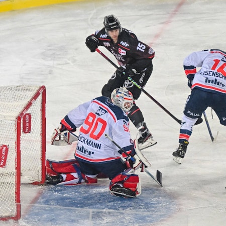 Louis-Marc Aubry Koelner Haie (schwarzes Trikot) beschäftigt Mannheims Torwart Felix Brückmann und Markus Eisenschmid (r.).