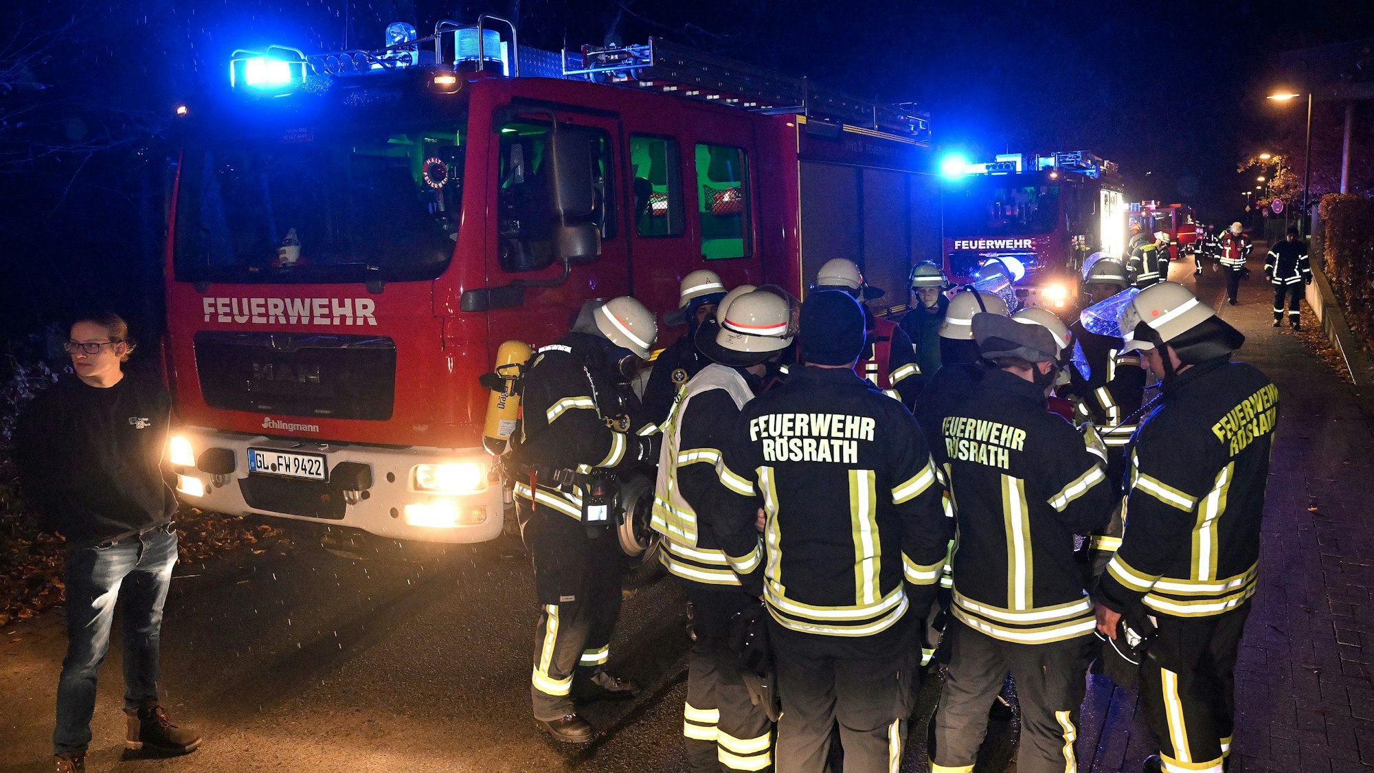 Rösrather Feuerwehrleute stehen vor einem Einsatzfahrzeug.