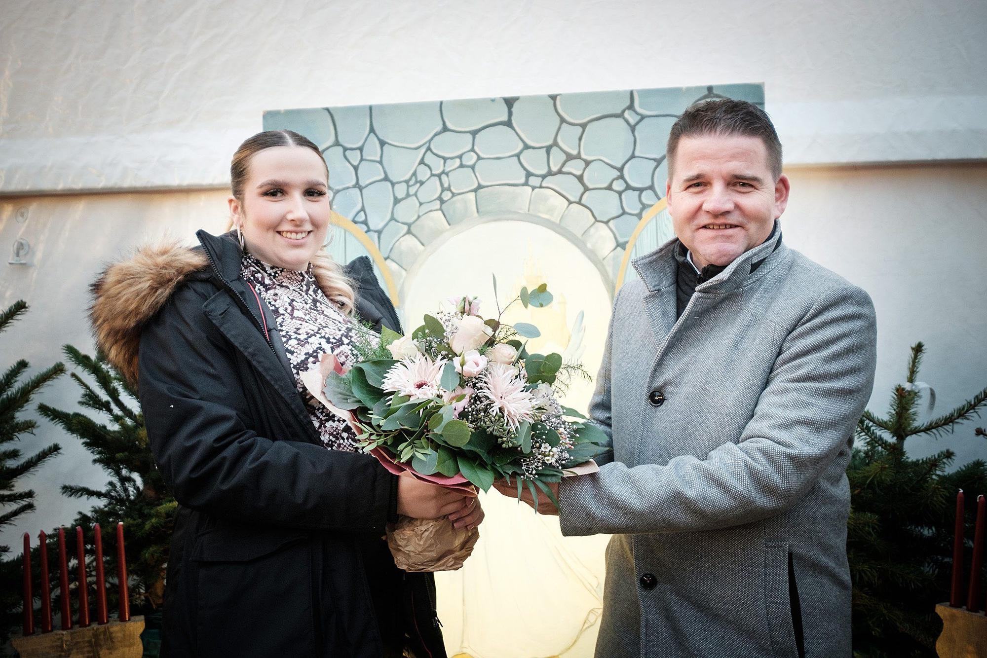 Bürgermeister Holger Jung überreicht Blumen an die Meckenheimer Blütenkönigin Celina Kotz, die auch 2023 ihren Heimatort präsentiert