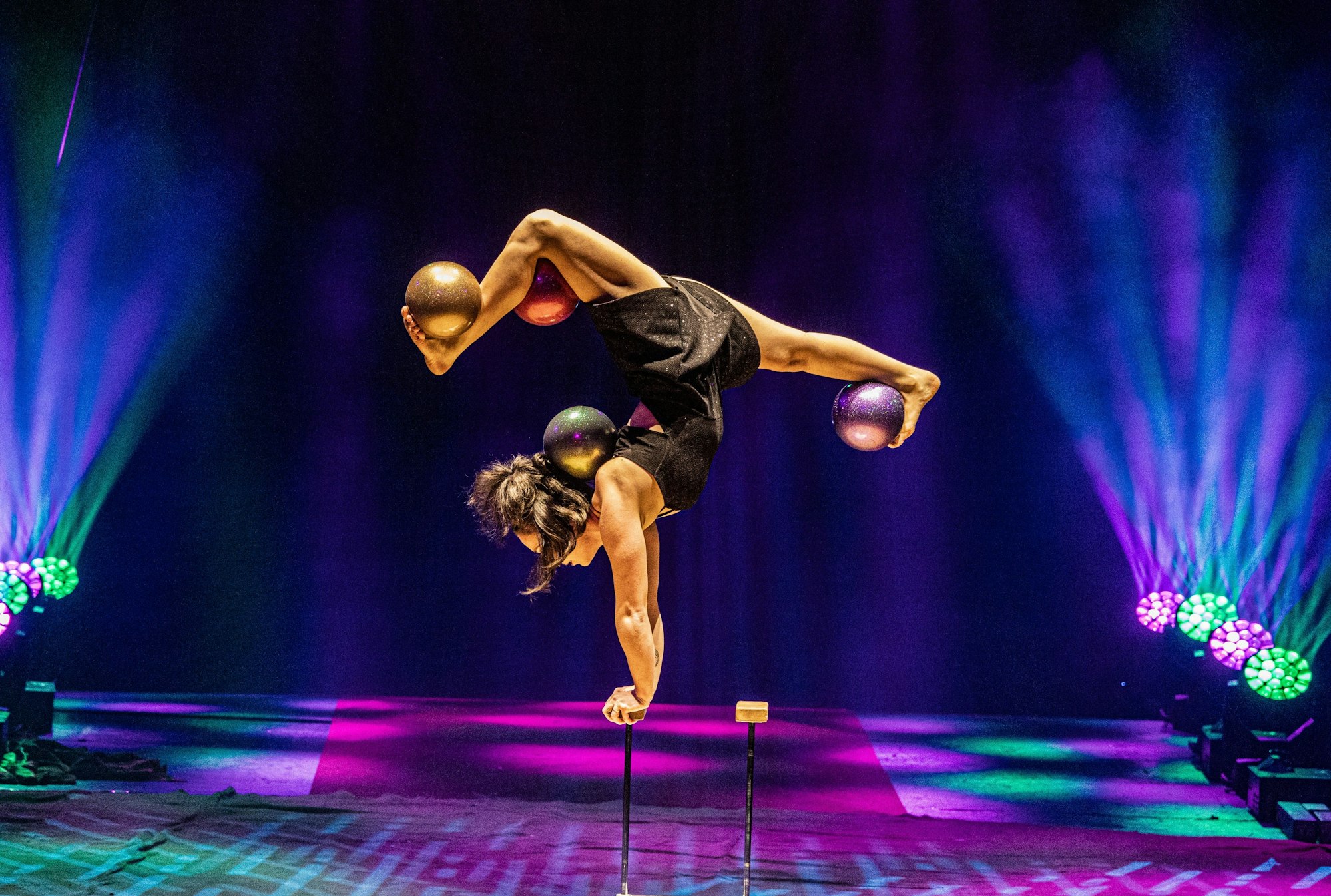 Die Artistin Tamara Khourchoudova balanciert mehrere Bälle mit ihren Füßen.