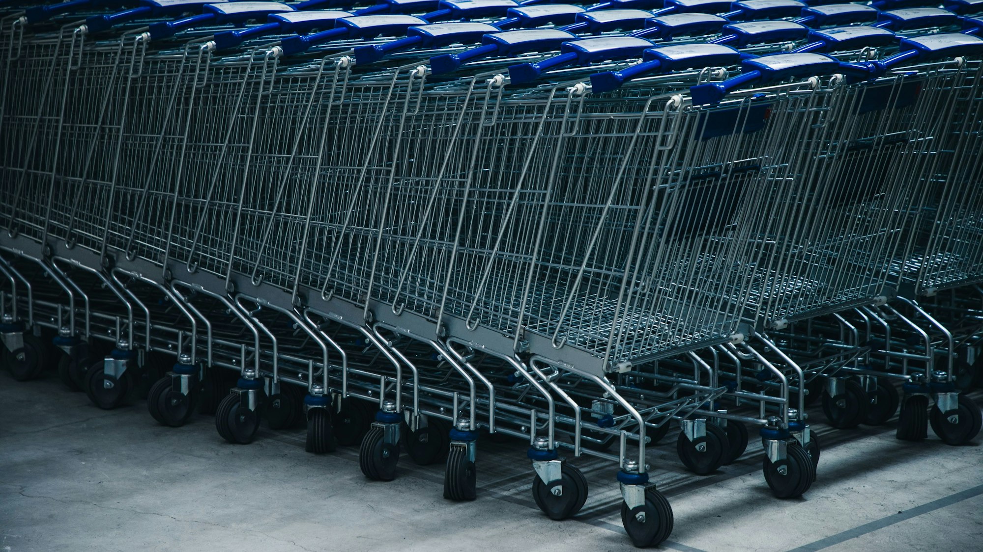 Leere Einkaufswagen stehen ineinandergeschoben auf einem Platz.