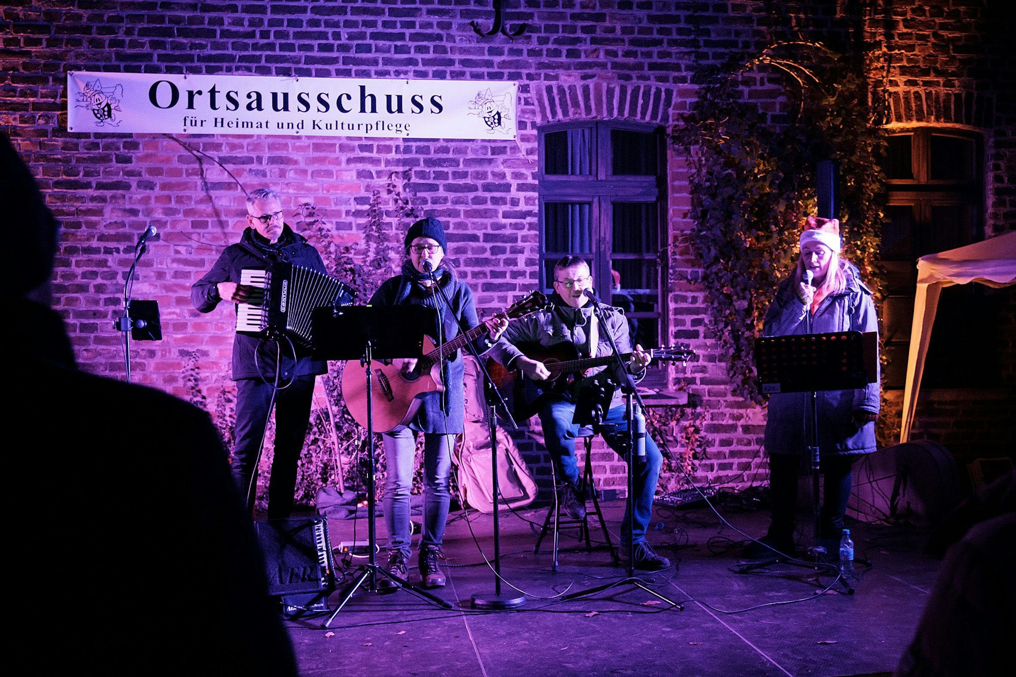 Musiker spielen am Alten Kloster auf dem Weihnachtsmarkt in Heimerzheim