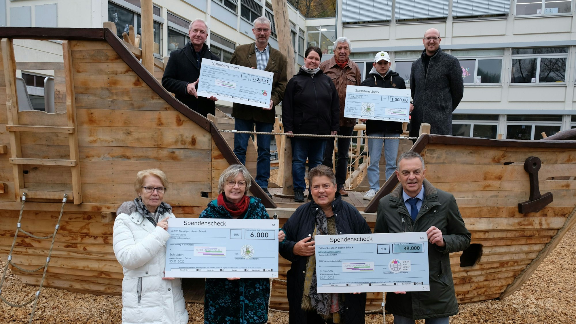 Die Spender halten die Schecks mit den Summen, die an die Astrid-Lindgren-Schule gehen.