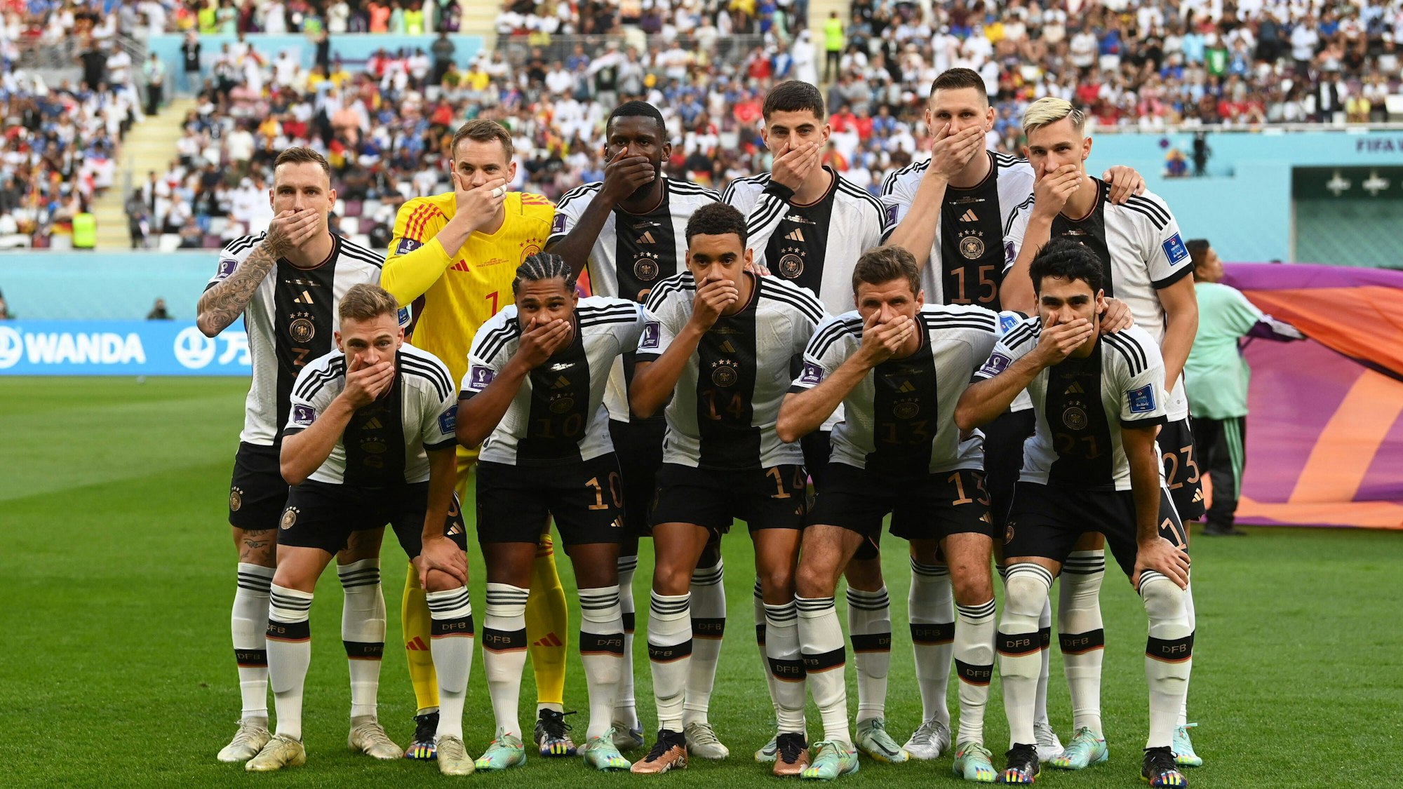 Die deutsche Nationalelf hielt sich beim 1. Spieltag (Deutschland – Japan) den Mund zu. Zu sehen sind David Raum, Torhüter Manuel Neuer, Antonio Rüdiger, Kai Havertz, Niklas Süle, Nico Schlotterbeck, Joshua Kimmich, Serge Gnabry, Jamal Musiala, Thomas Müller und İlkay Gündoğan.