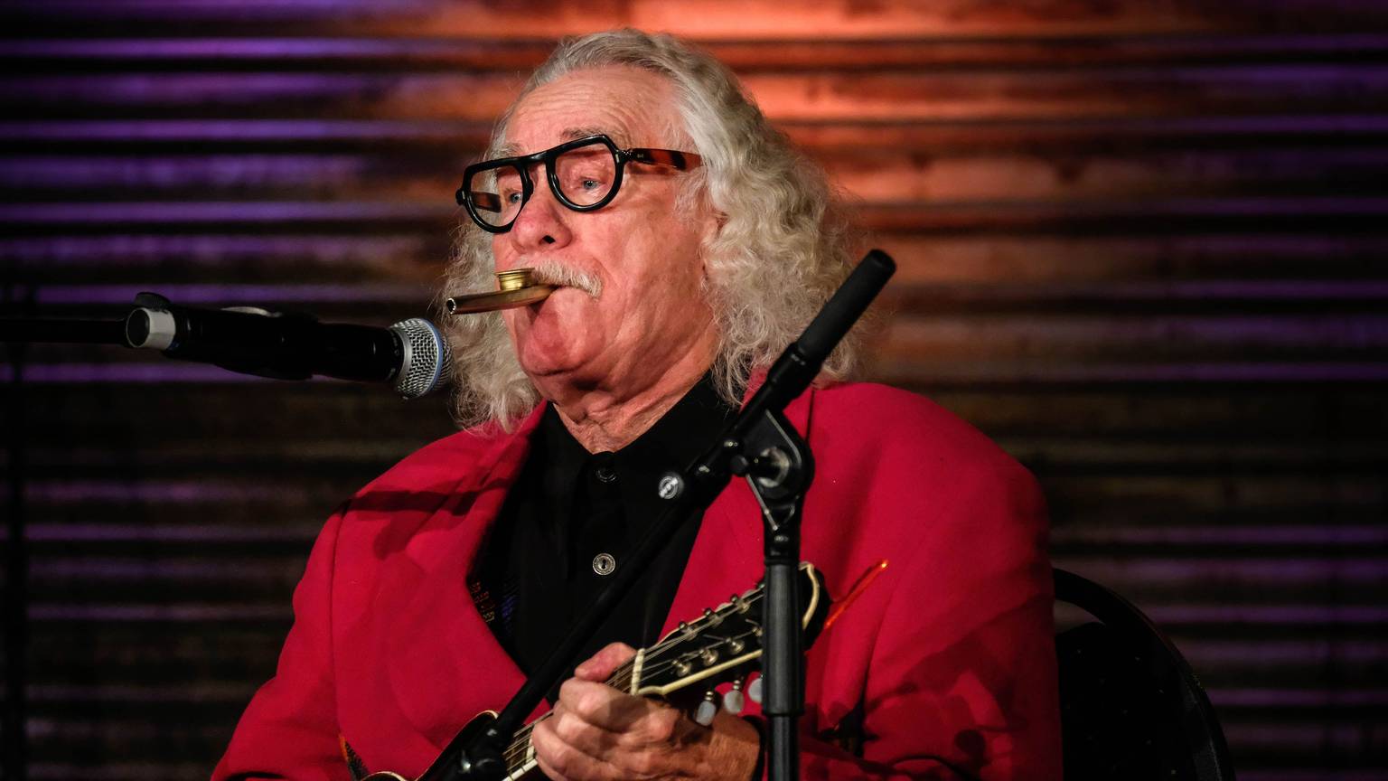 Hans Süper spielt Gitarre bei einem Auftritt.