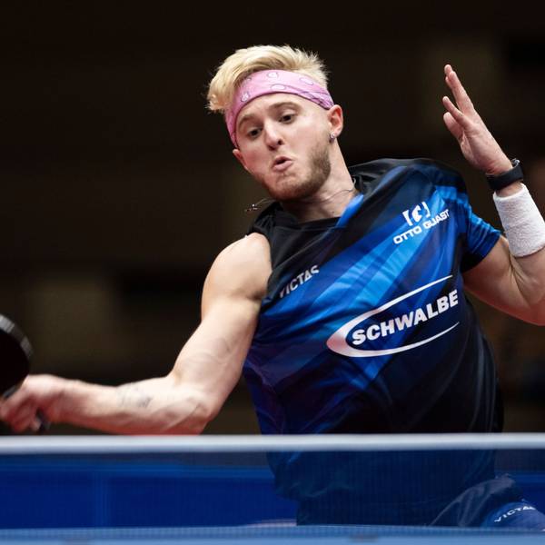 Zu sehen ist ein junger Tischtennisspieler, der den Ball mit der Vorhand über das Netz schlägt.