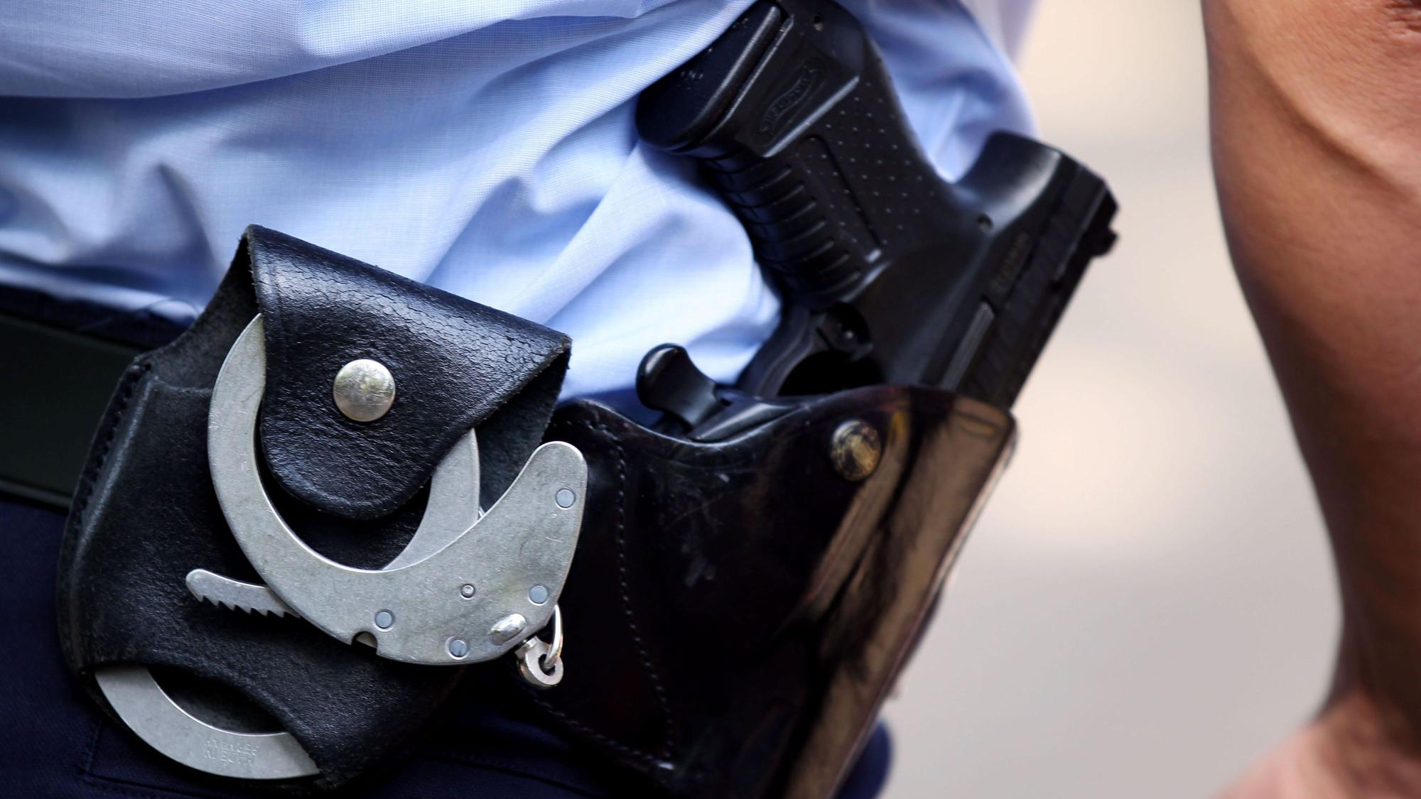 Ein Polizist mit Handschellen und Pistole am Gürtel