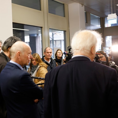 Kläger Georg Menne (M l) steht mit einem seiner Anwälte nach der Verhandlung im Landgericht Köln und beantwortet der Presse Fragen