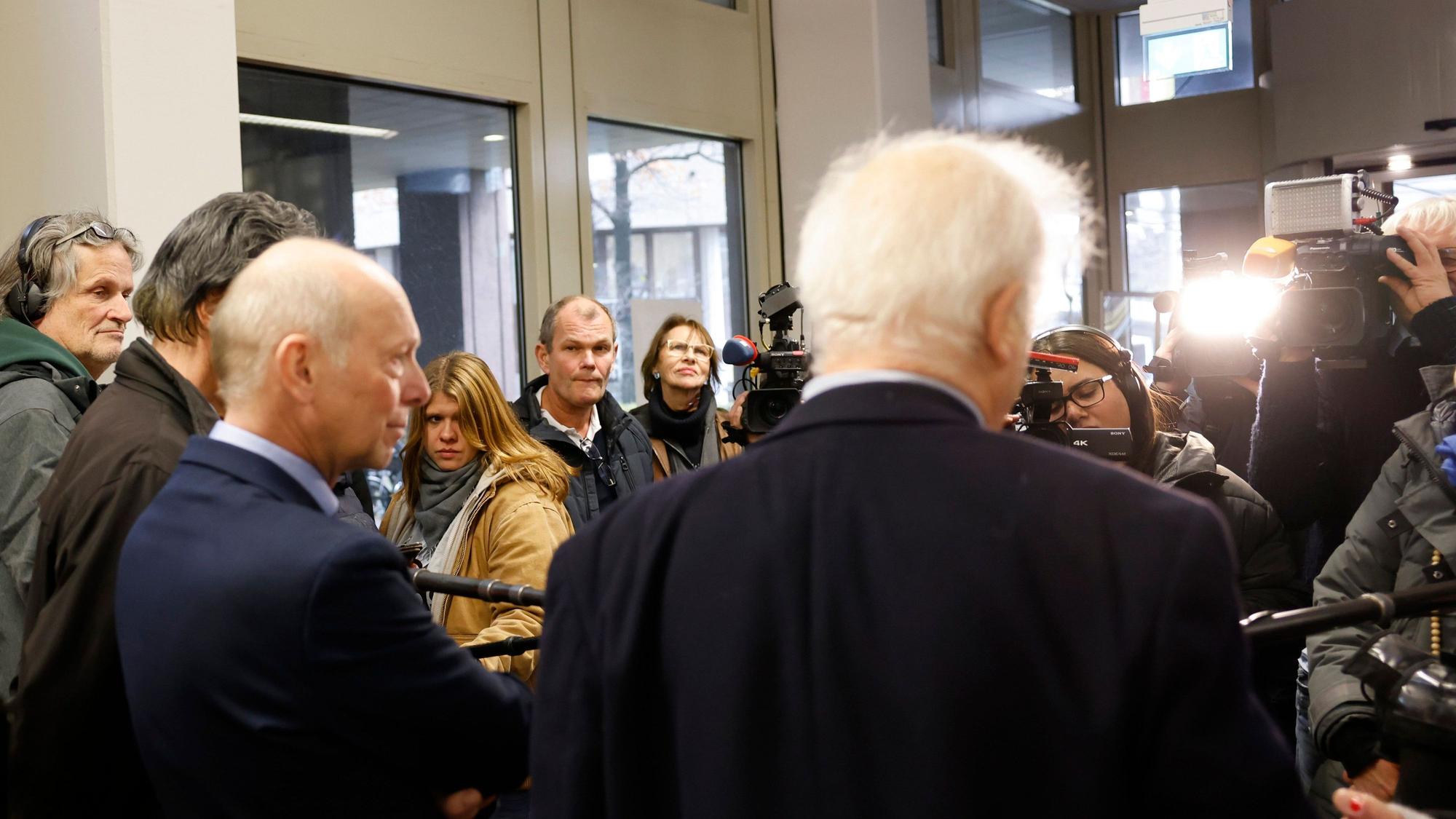 Kläger Georg Menne (M l) steht mit einem seiner Anwälte nach der Verhandlung im Landgericht Köln und beantwortet der Presse Fragen