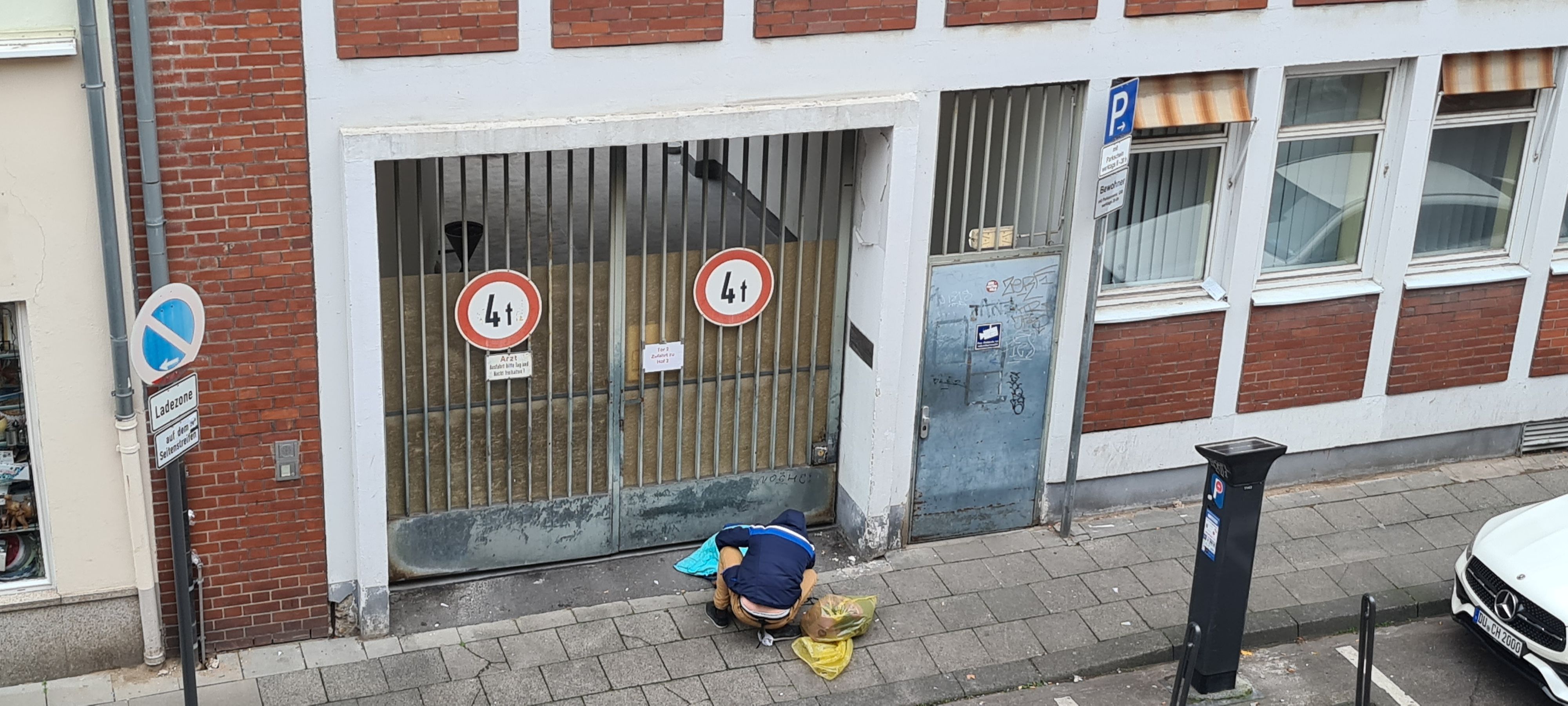 Ein suchtkranker Mann sitzt in der Lungengasse vor der verschlossenen Tür des Drogenkonsumraums.