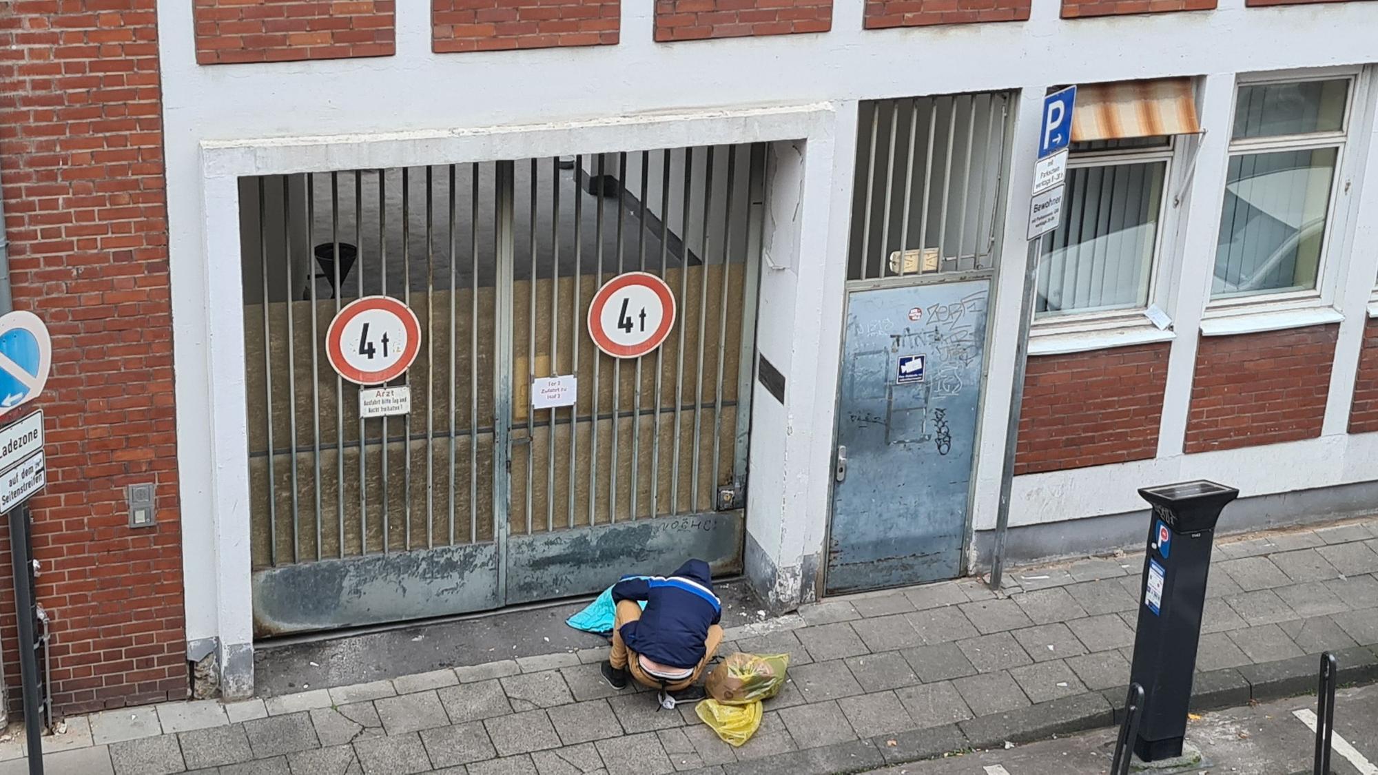 Ein suchtkranker Mann sitzt in der Lungengasse vor der verschlossenen Tür des Drogenkonsumraums.