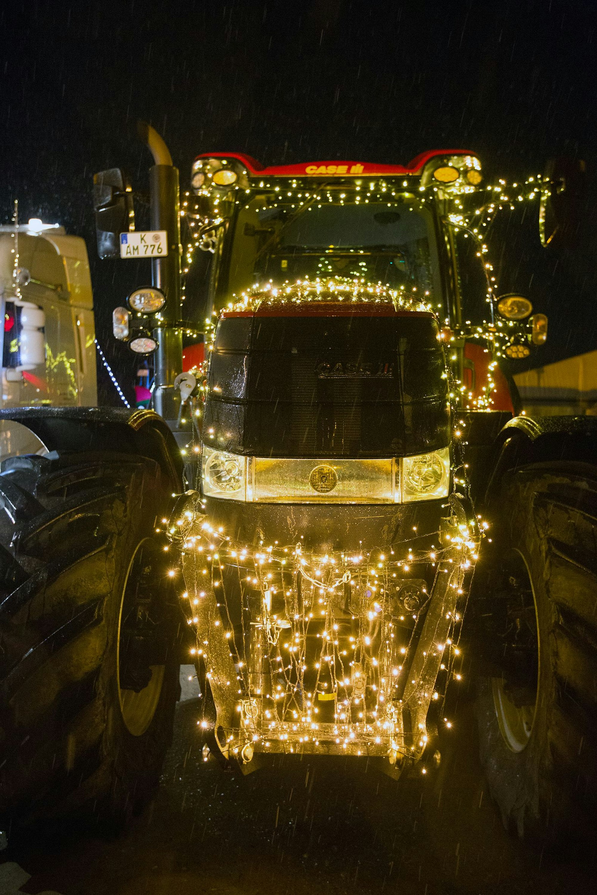Ein mit Lichterketten behängter Trecker ist frontal zu sehen.