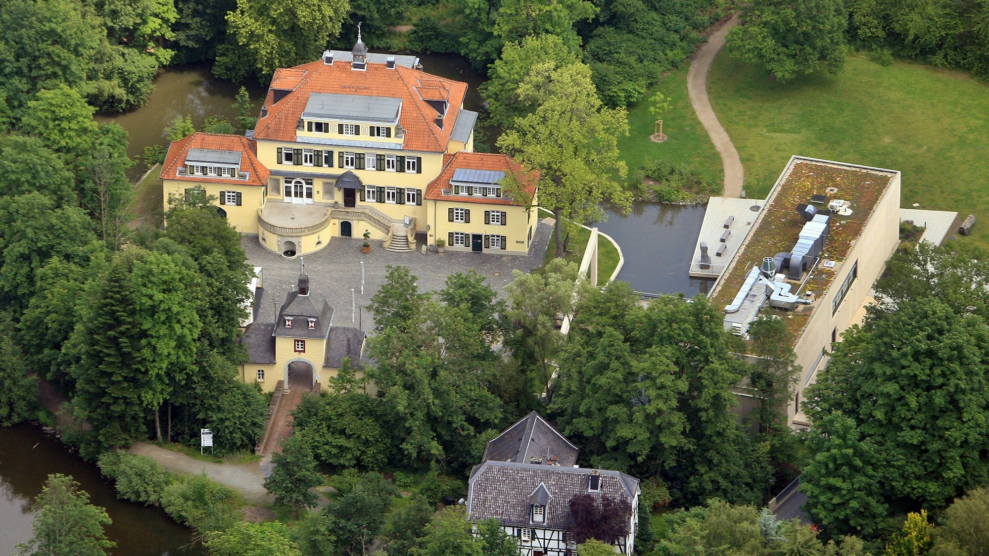Luftbild von Schloss Eulenbroich mit Werkstattgebäude, Torburg, Sülzwiesen, Sülzauen.l