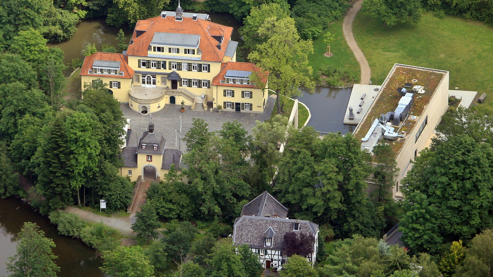 Ein Blick von oben auf Schloss Eulenbroich und das Werkstattgebäude.