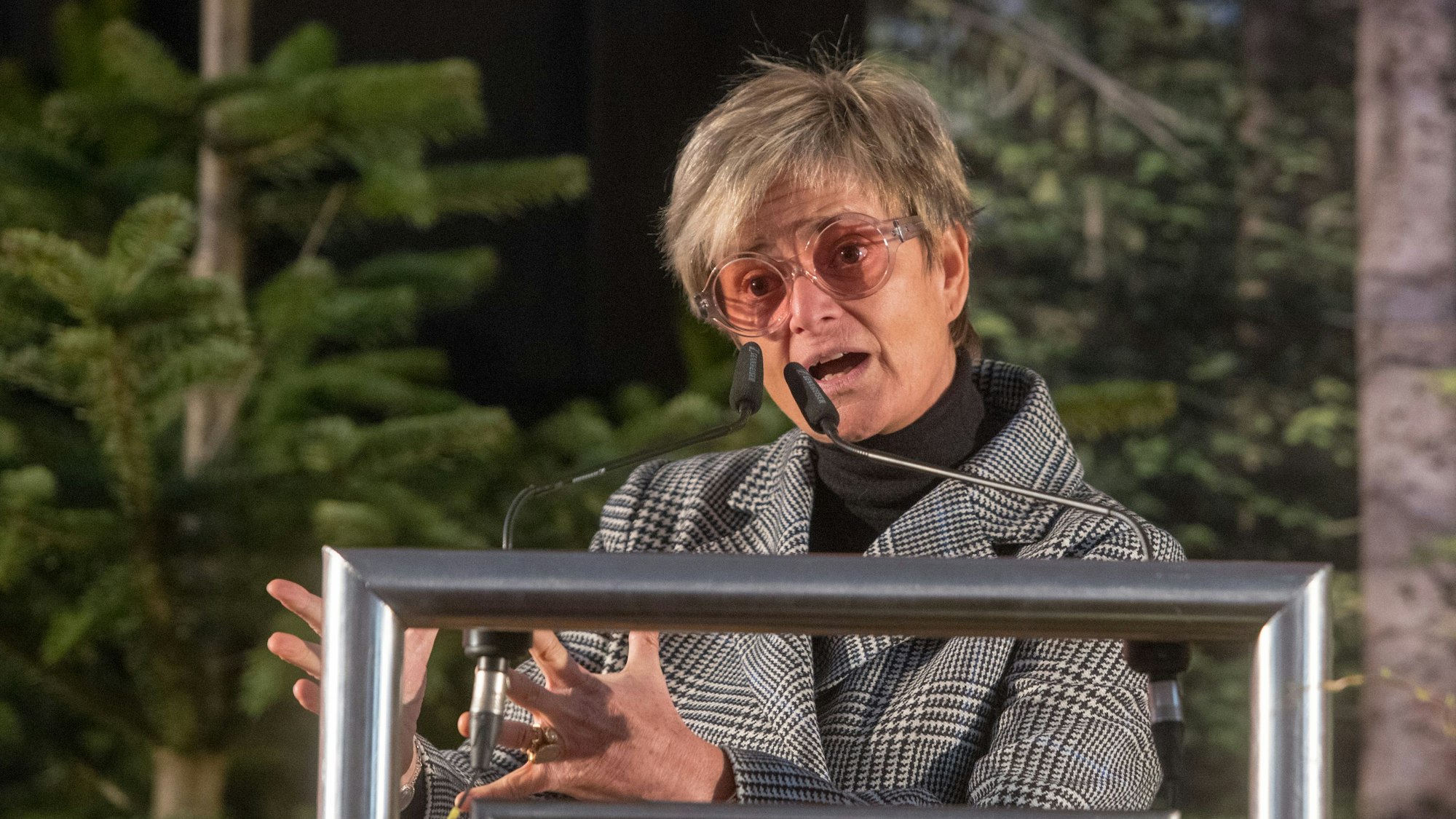 Gloria von Thurn und Taxis spricht während der Festveranstaltung anlässlich des 100-jährigen Bestehens des Bayerischen Waldbesitzerverbands im Schloss Emmeram. Sie hebt die Hände und redet in zwei Mikros. Hinter ihr stehen Tannenbäume.