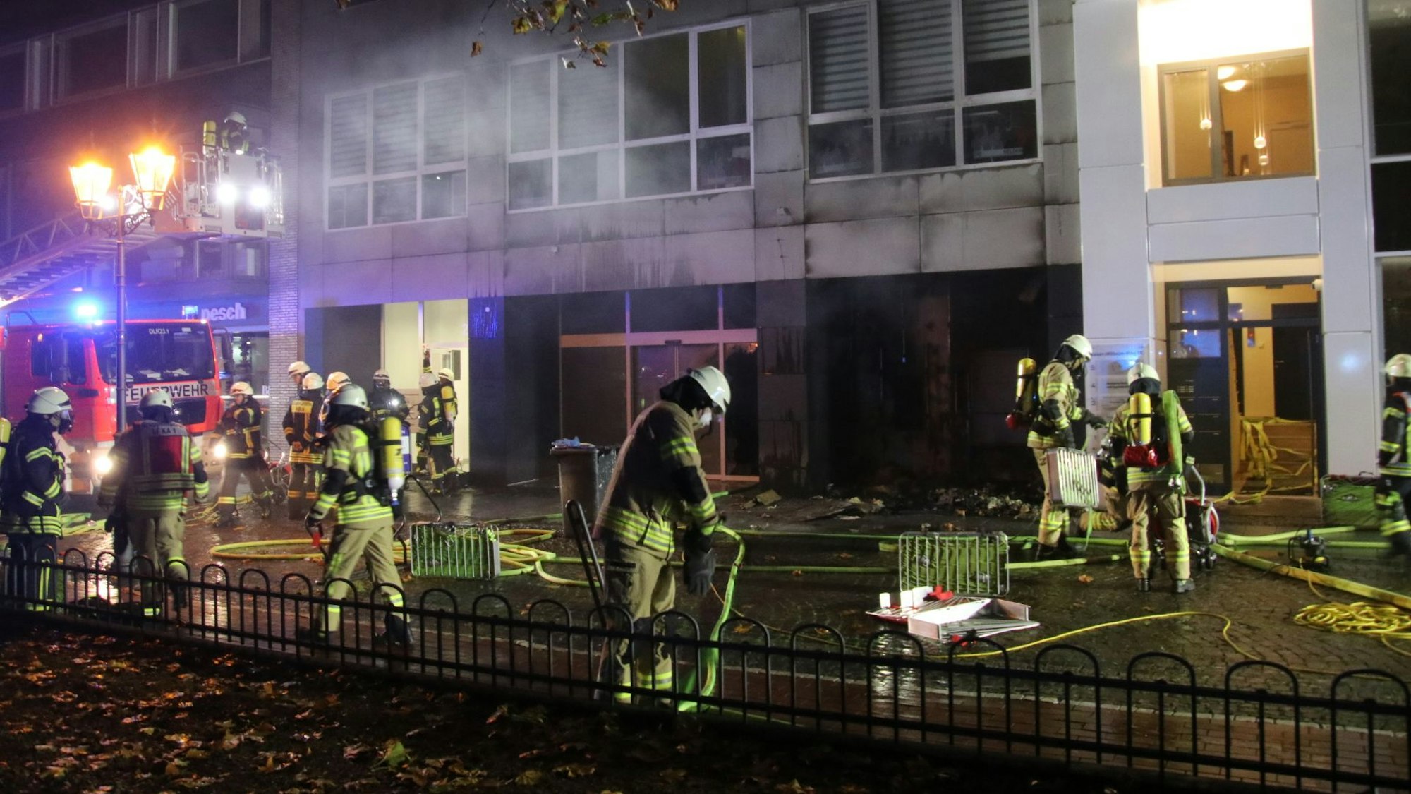 Feuerwehrleute löschen einen Brand am Kaiser-Wilhelm-Ring 20 in Köln. Im Hintergrund ist ein Einsatzfahrzeug zu sehen.