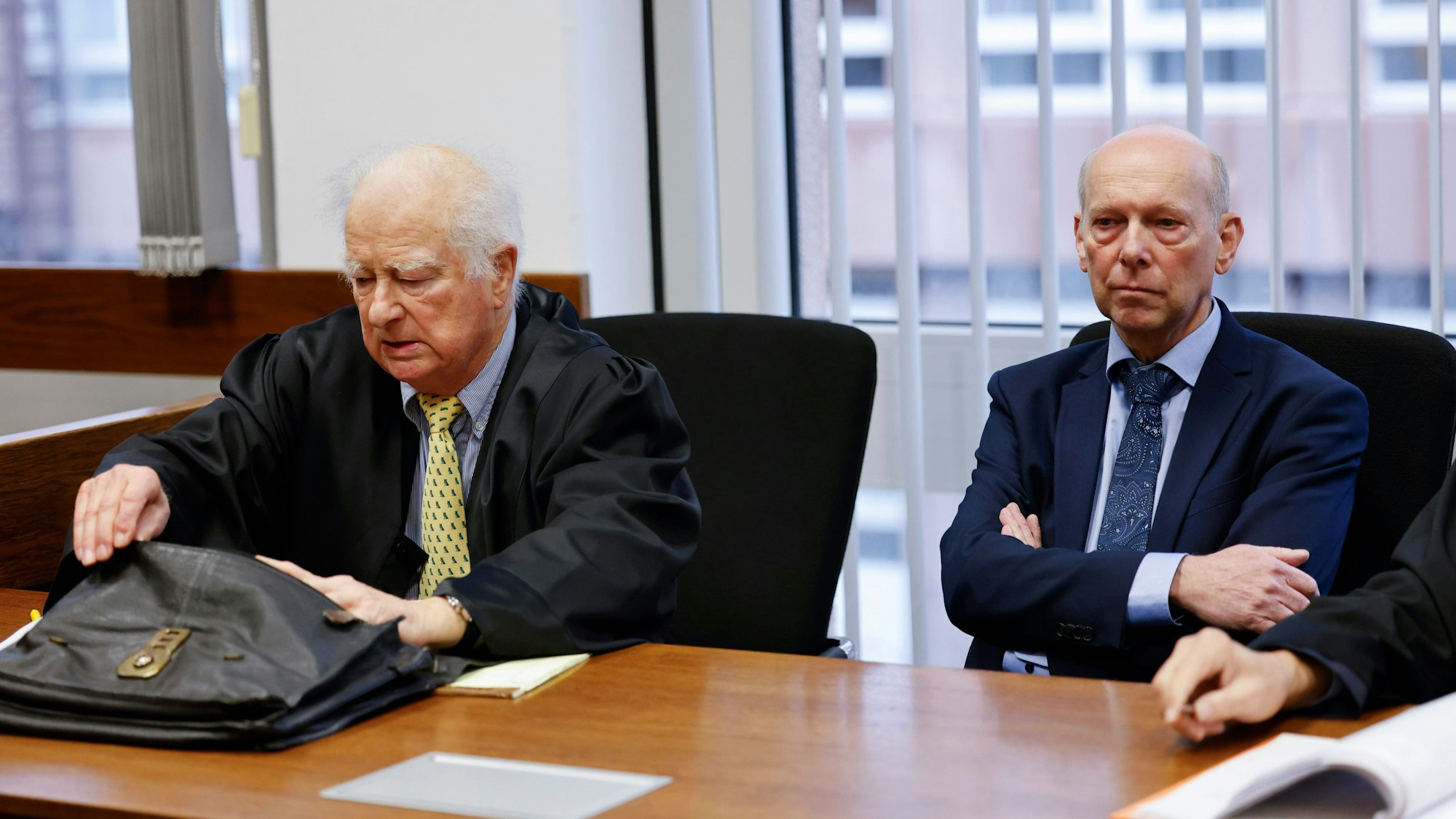 06.12.2022, Nordrhein-Westfalen, Köln: Kläger Georg Menne (r) sitzt mit einem seiner Anwälte Eberhard Luetjohann vor der Verhandlung im Gerichtssaal im Landgericht Köln. Der 62-Jährige verklagt das Kölner Erzbistum auf mehr als 700.000 Euro Schmerzensgeld - weil er Opfer sexueller Gewalt durch einen katholischen Priester geworden sei.