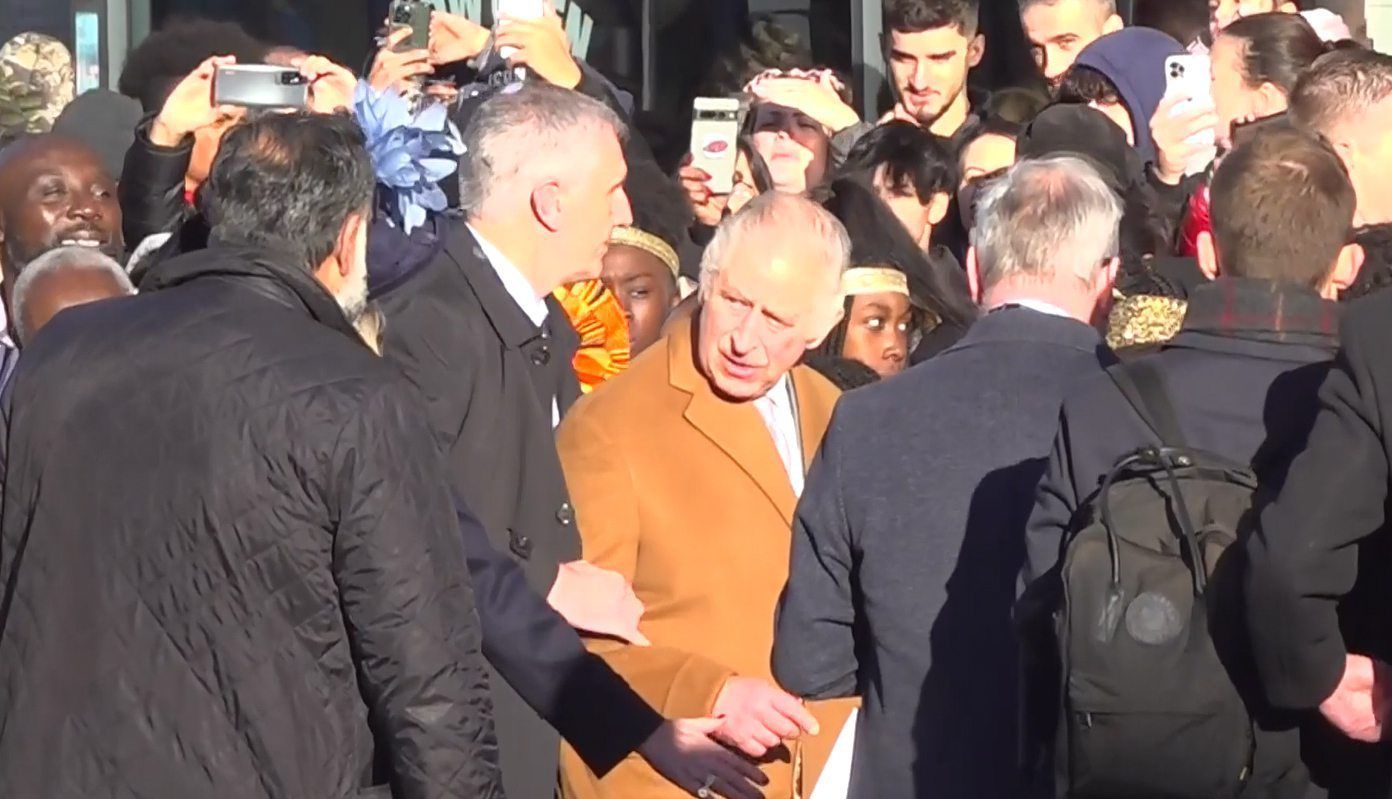 Das Bildschirmfoto aus einem PA-Video, zeigt, wie Sicherheitsbeamte König Charles III. von der Menge wegführen.