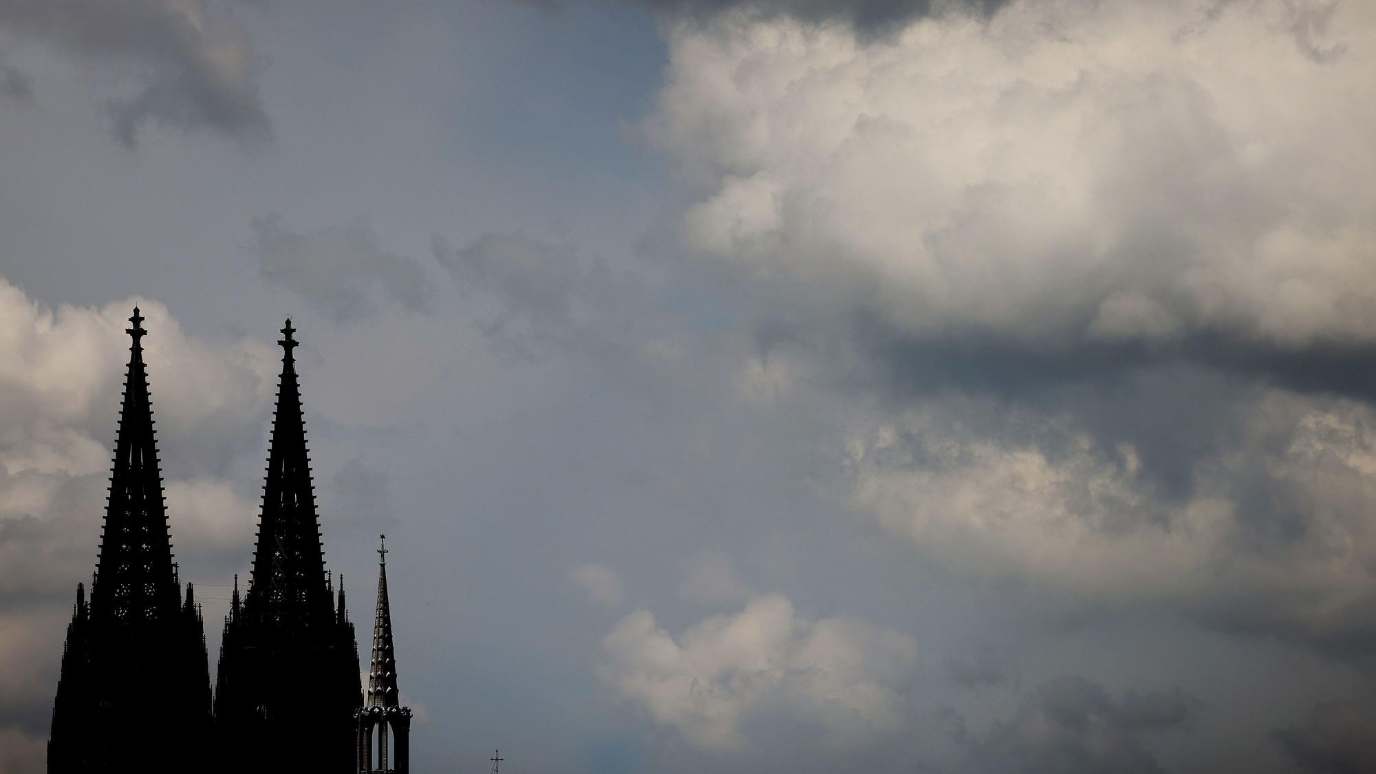 ARCHIV - 28.05.2021, Nordrhein-Westfalen, Köln: Wolken ziehen am Dom vorbei.