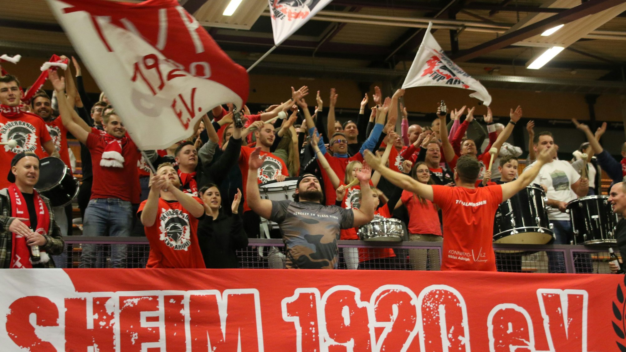 Die „Räuberbande“, die Fans des TV Palmersheim, schwenkt Fahnen und bejubelt von der Tribüne die Spieler auf dem Feld.