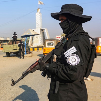 Ein Taliban mit einer Maschinenpistole steht an einem Checkpoint auf einer Straße in der Stadt Jalalabad