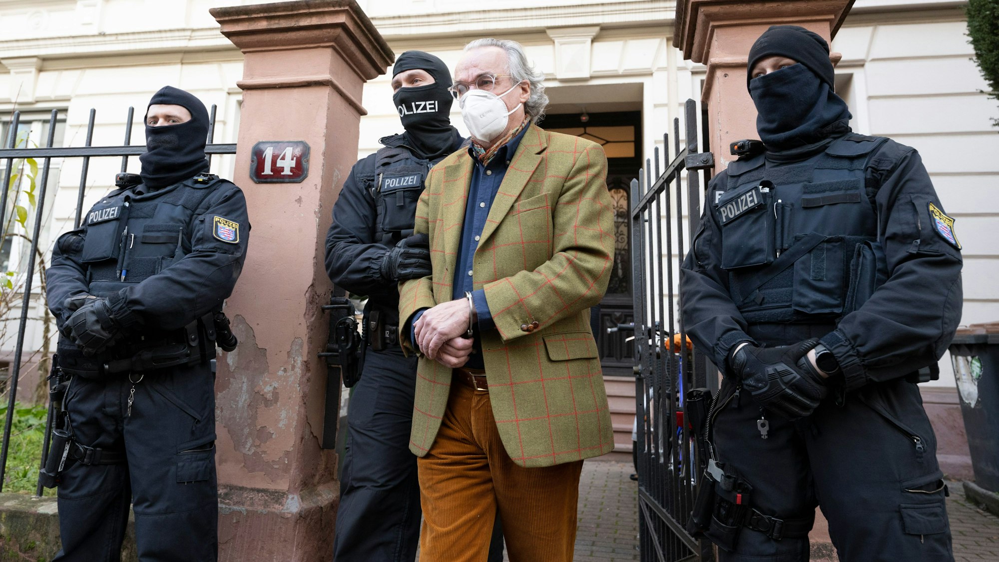 Bei einer Razzia gegen sogenannte „Reichsbürger“ führen vermummte Polizisten Heinrich XIII Prinz Reuß zu einem Polizeifahrzeug