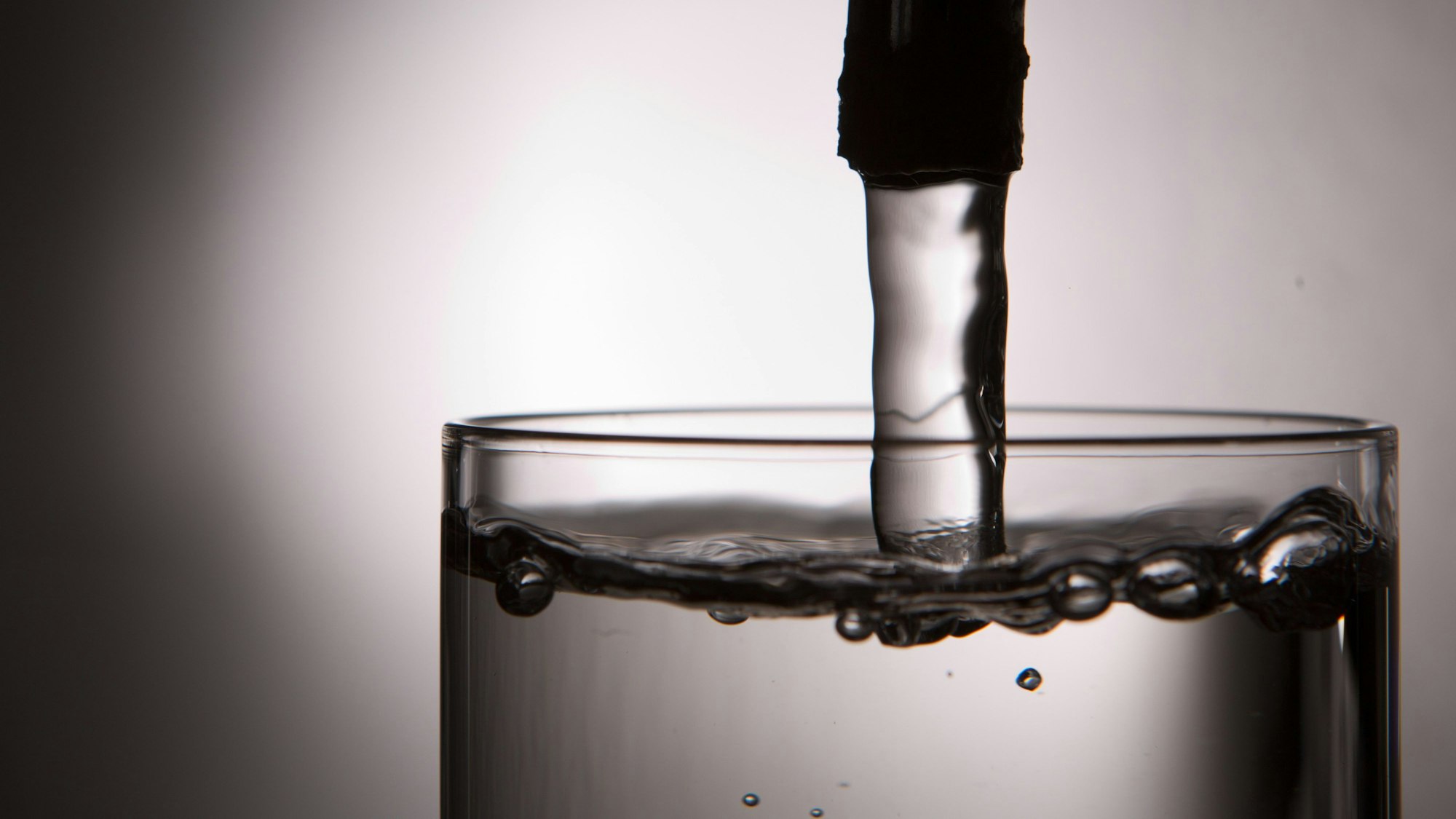 ILLUSTRATION - Leitungswasser läuft in ein Glas.