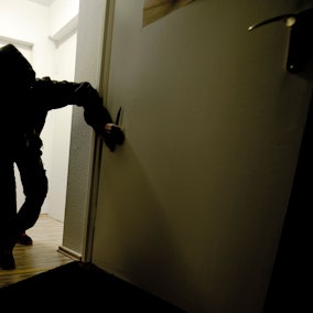 Ein Einbrecher schleicht durch eine dunkle Wohnung (Symbolfoto).