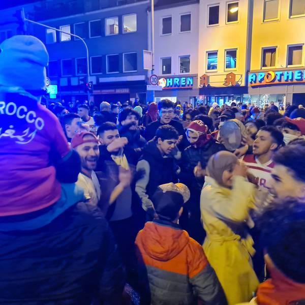 Das Bild zeigt feiernde Fans nach dem Sieg Marokkos gegen Spanien bei der Fußball-WM in Bergheim.