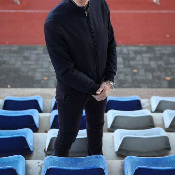 Ingo Froböse steht auf einem Sportplatz und guckt in die Kamera.
