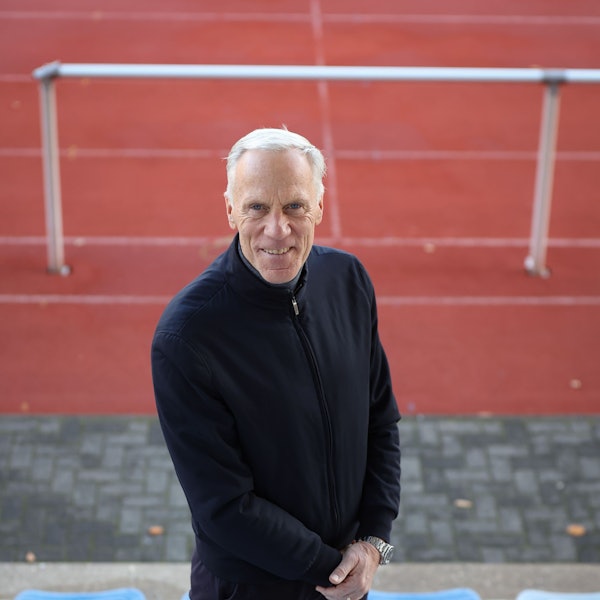 Ingo Froböse steht auf einem Sportplatz und guckt in die Kamera.
