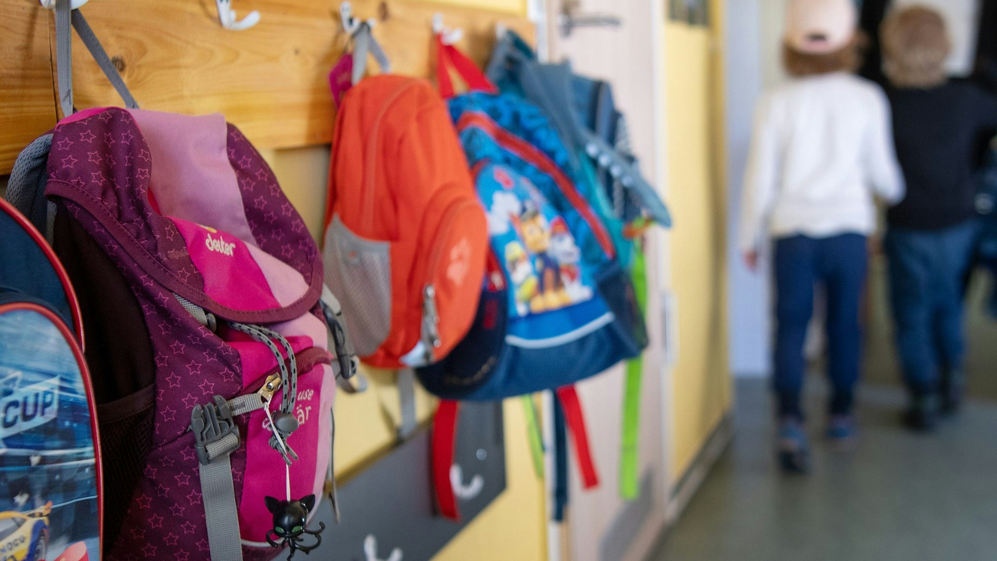 Kinderrucksäcke hängen im Eingangsbereich eines Kindergartens.