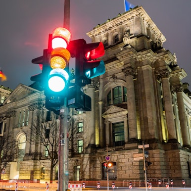 ARCHIV - 26.11.2021, Berlin: Eine Ampel leuchtet in einer Aufnahme mit Langzeitbelichtung am Morgen vor dem Reichstagsgebäude in allen drei Phasen.