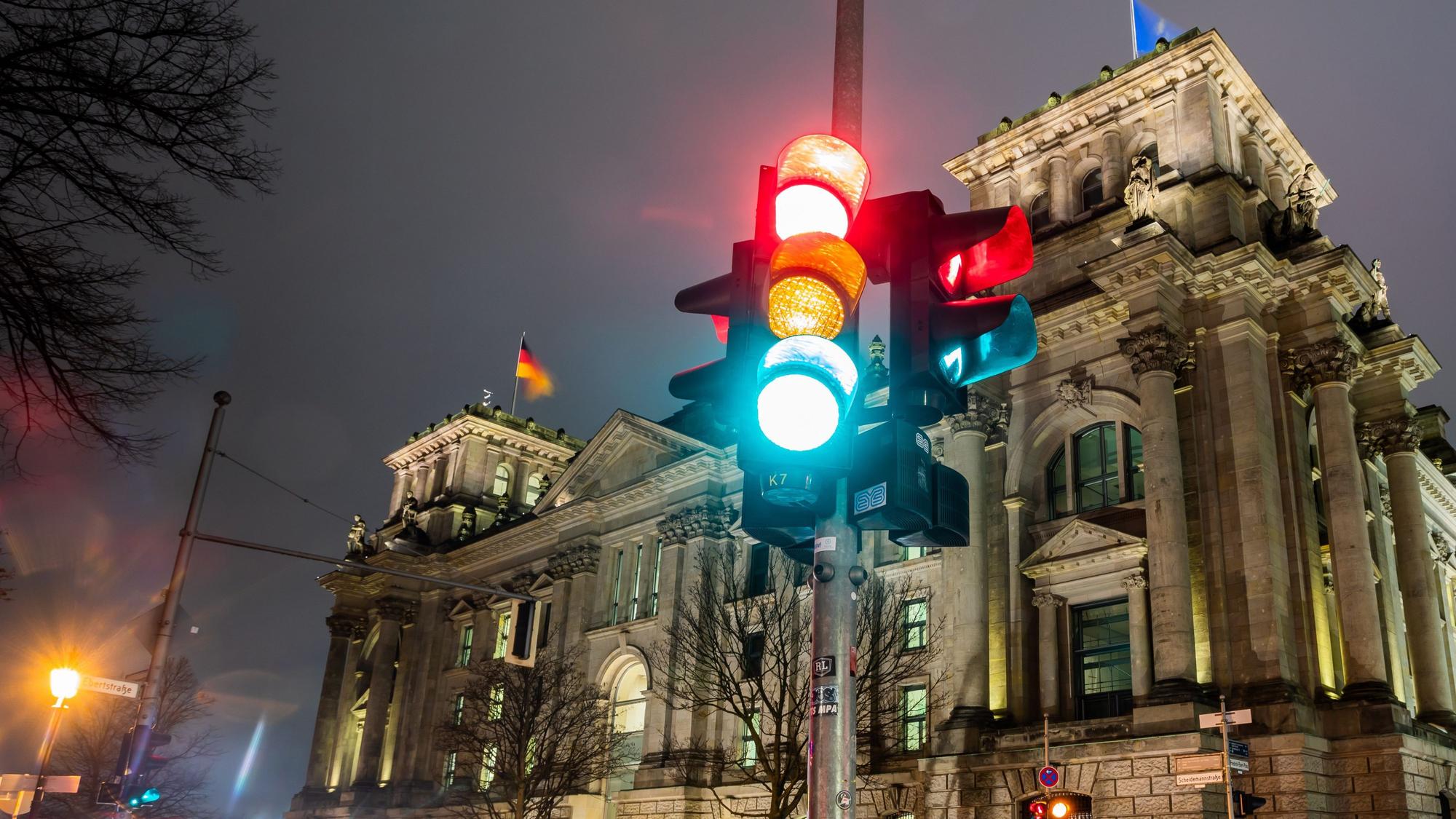 ARCHIV - 26.11.2021, Berlin: Eine Ampel leuchtet in einer Aufnahme mit Langzeitbelichtung am Morgen vor dem Reichstagsgebäude in allen drei Phasen.