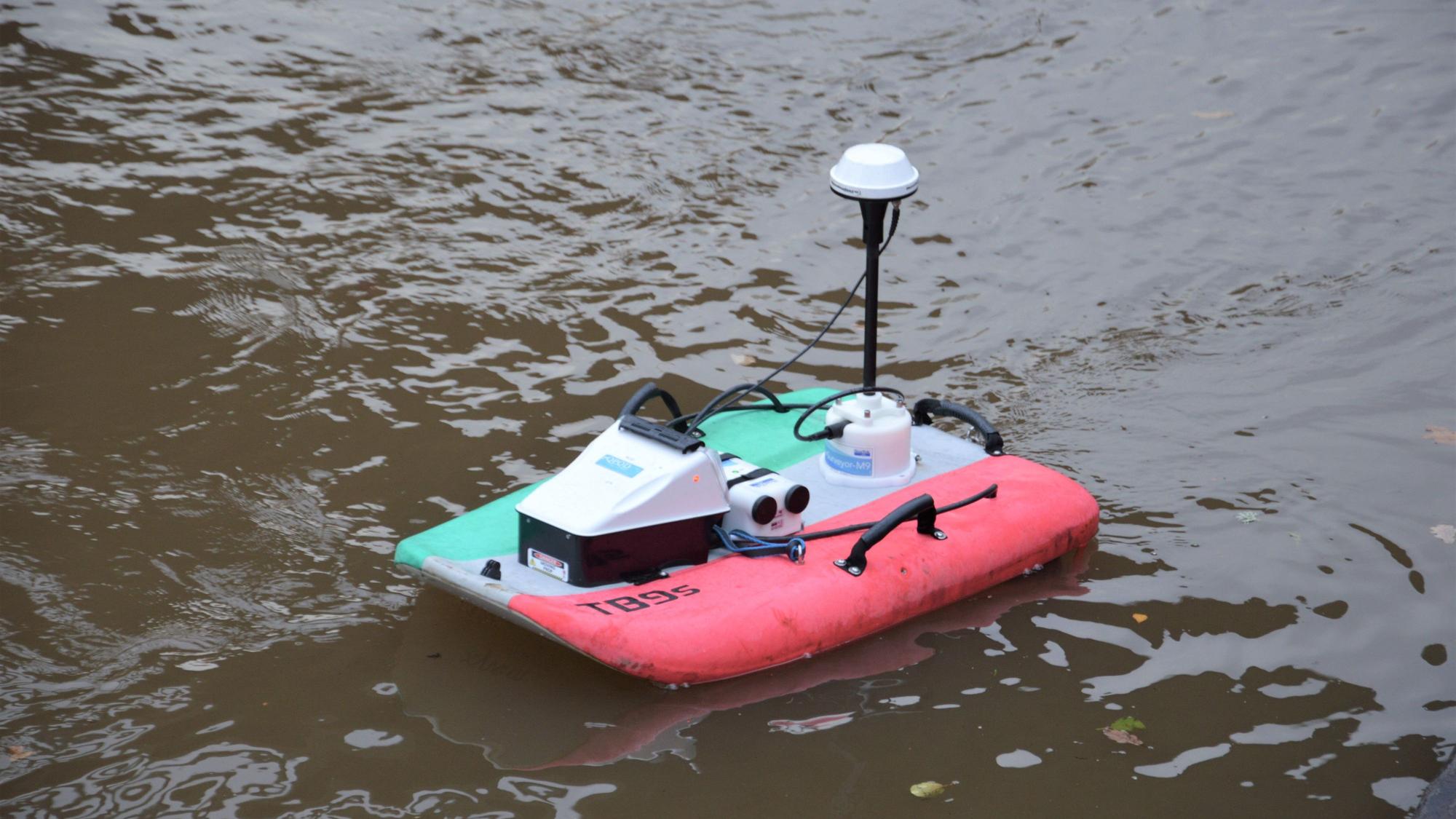Ein Miniboot mit technischen Apparaten fährt auf der Urft.