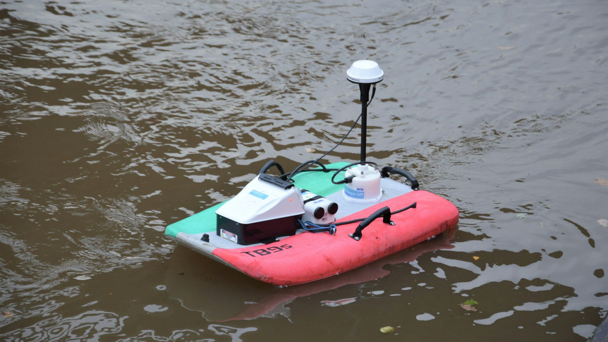 Ein Miniboot mit technischen Apparaten fährt auf der Urft.