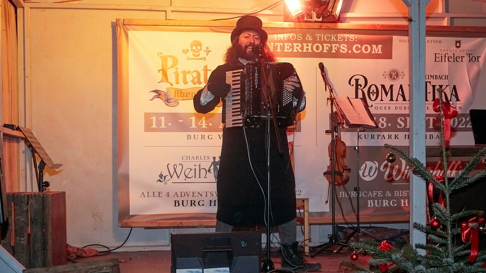 Der Folksänger Felix Clement, stilvoll mit Gehrock und Zylinder gekleidet, spielt auf einem Akkordeon irische, schottische und englische Weihnachtslieder.