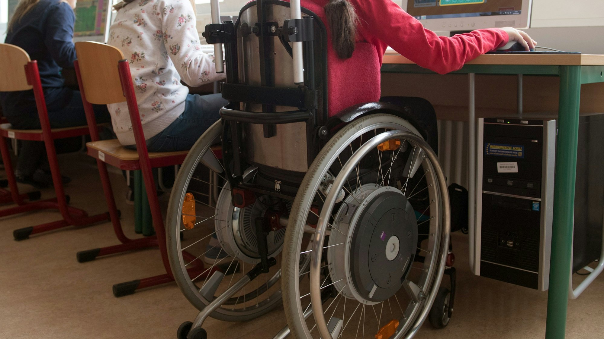 Symbolbild: Eine Person im Rollstuhl bedient einen Computer.