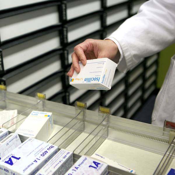 Eine Apothekerin nimmt in einer Apotheke in Köln ein Medikament aus dem Schrank.