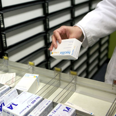 Eine Apothekerin nimmt in einer Apotheke in Köln ein Medikament aus dem Schrank.