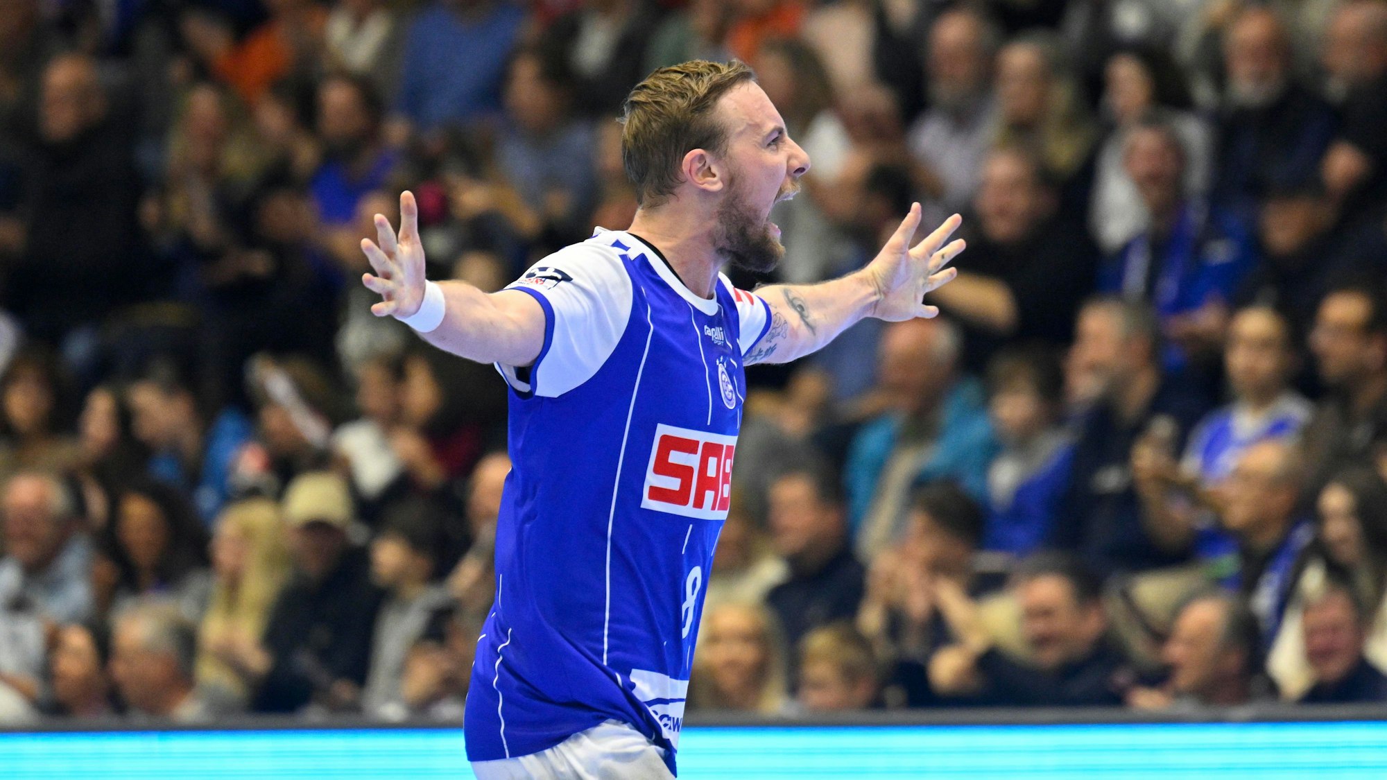 Lukas blome vom VfL Gummersbach
jubelt in der Schwalbe Arena mit ausgestreckten Armen.