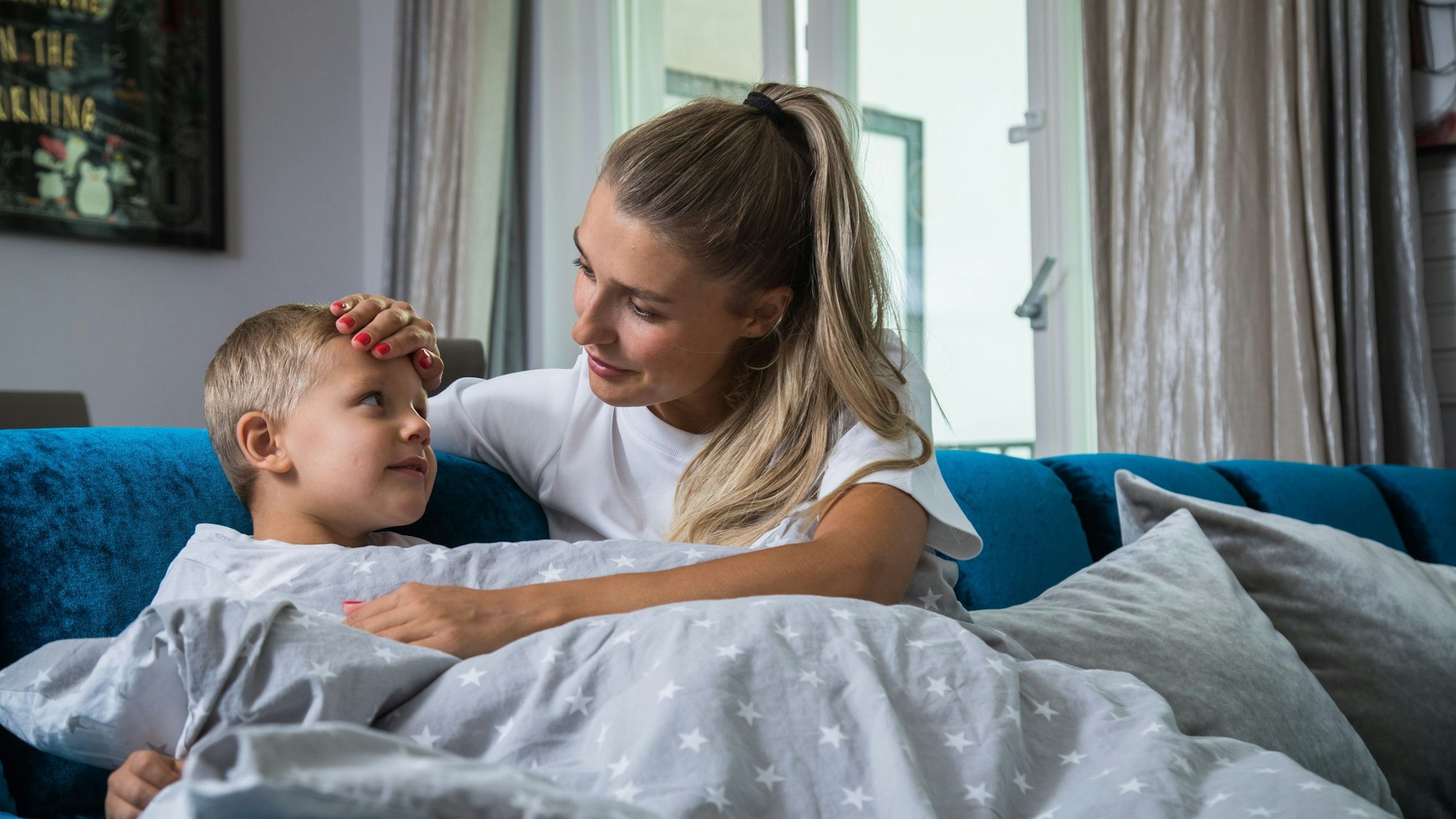 Eine Mutter pflegt ihr krankes Kind.