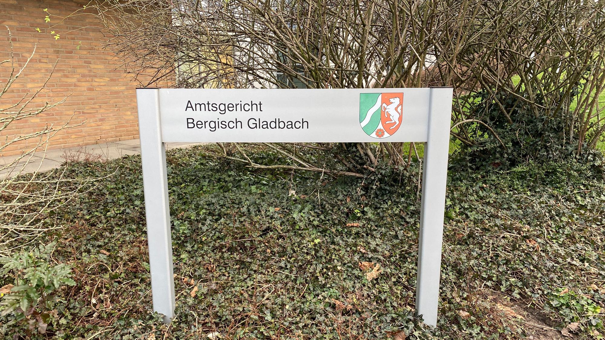 Ein Schild mit der Aufschrift „Amtsgericht Bergisch Gladbach“ steht im Grün vor dem Gerichtsgebäude.