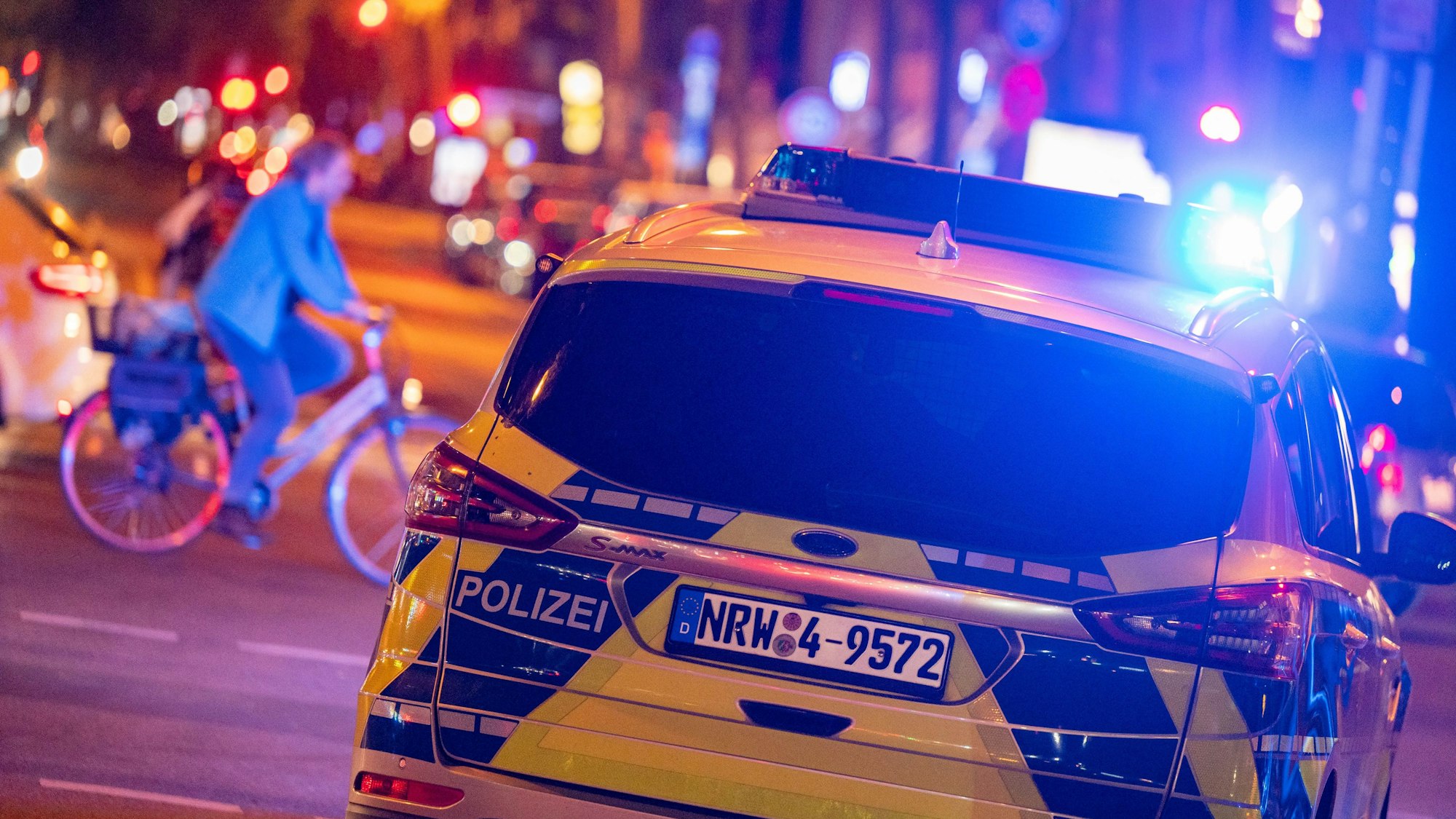 Ein Polizeiwagen fährt mit Blaulicht über eine Straße.