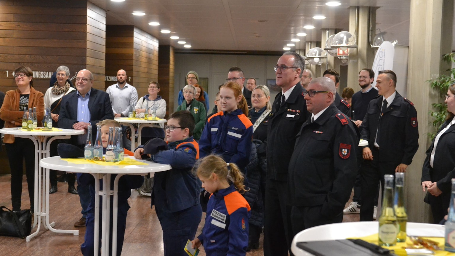 Im Euskirchener Kreishaus verfolgen zahlreiche Ehrenamtler, darunter eine Reihe von Feuerwehrleuten und Mitglieder der Jugendwehren, die Ausstellungseröffnung.