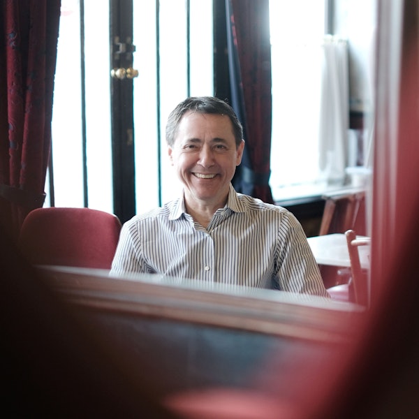 Portrait eines lächelnden Mannes mit gesteiftem Hemd.