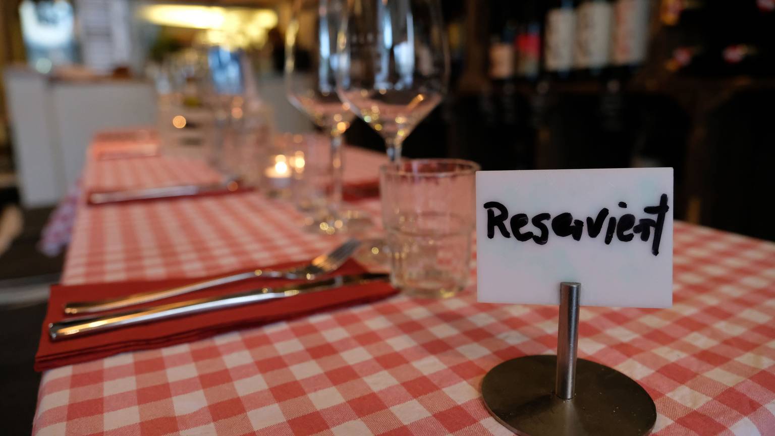Ein Schild mit der Aufschrift „Reserviert“ steht auf einem Tisch in einem Restaurant. Es handelt sich um ein Symbolbild.