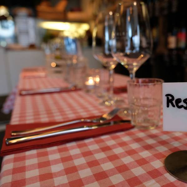 Ein Schild mit der Aufschrift „Reserviert" steht auf einem Tisch in einem Restaurant