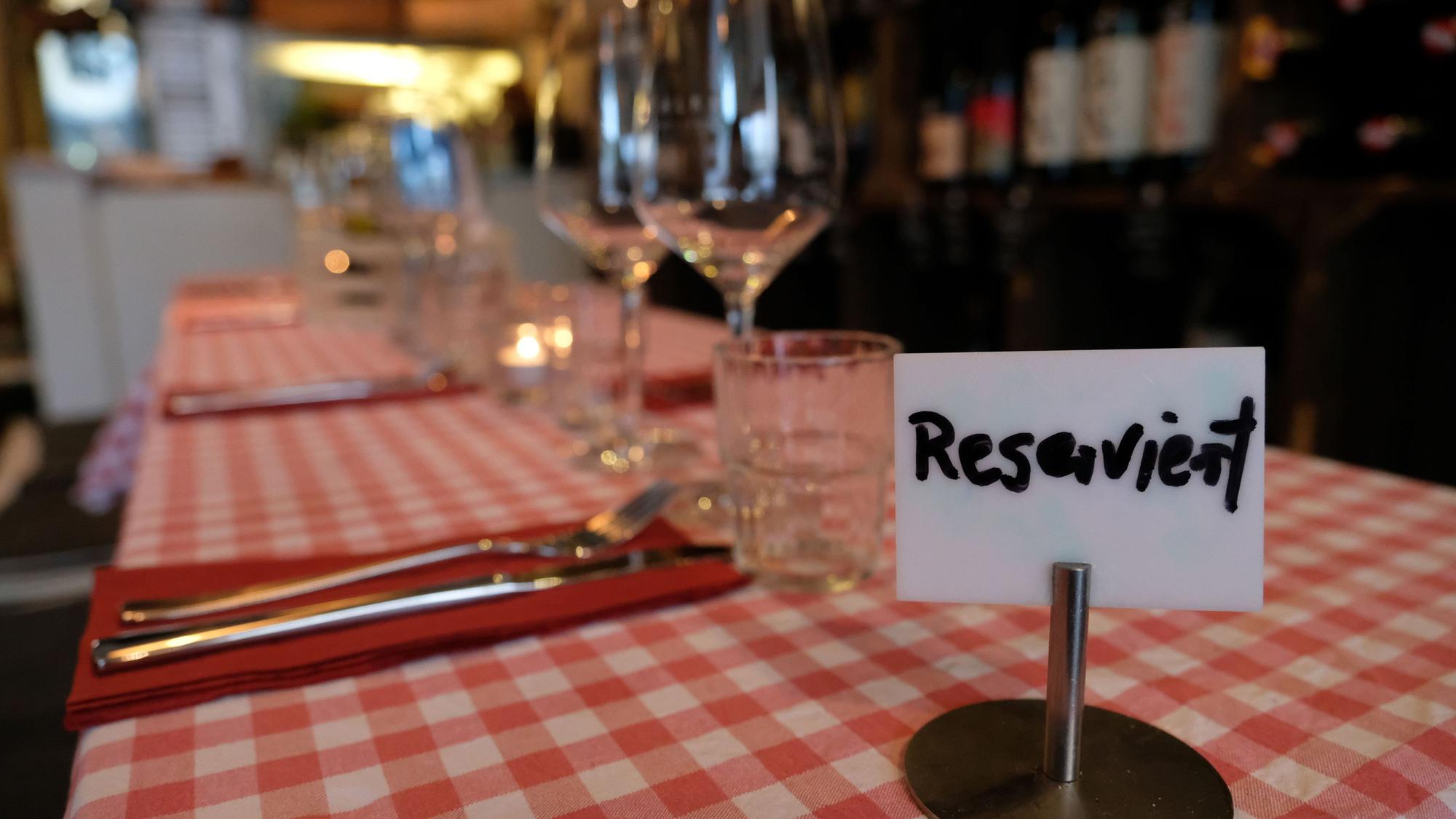 Ein Schild mit der Aufschrift „Reserviert" steht auf einem Tisch in einem Restaurant